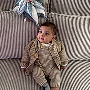 Constant a rejoint le concours — aidez-le/la à gagner de superbes lots ! baby, infant, knitted_clothing, socks, couch, plush_toy, teddy_bear, soft_furniture, beige, texture, cute, child, indoors, portrait, seated, young_child, cozy, warm_clothing, comfort, toy