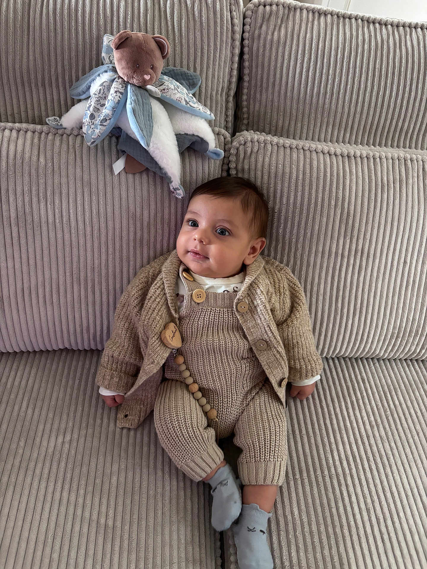 Constant a rejoint le concours — aidez-le/la à gagner de superbes lots ! baby, infant, knitted_clothing, socks, couch, plush_toy, teddy_bear, soft_furniture, beige, texture, cute, child, indoors, portrait, seated, young_child, cozy, warm_clothing, comfort, toy