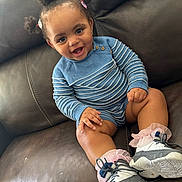 Germany joined the competition — help win amazing prizes! toddler, child, smiling, sitting, couch, leather, blue_sweater, striped_clothing, sneakers, pink_socks, hair_buns, hair_clips, happy, indoors, cute, portrait, baby, person, fashion, casual_wear