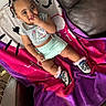baby, child, girl, pigtails, smiling, blanket, couch, leather, clothing, sitting, shoes, socks, indoor, cute, happy, person, portrait, recreational, colorful, comfortable