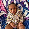 Germany joined the competition — help win amazing prizes! baby, child, smiling, braided_hair, beads, robe, floral_pattern, blanket, colorful, happy, cute, indoors, portrait, sitting, skin, hands, legs, face, expression, cozy