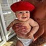 Côme a rejoint le concours — aidez-le/la à gagner de superbes lots ! baby, beret, red_hat, tattoo, man, diaper, smile, skin, hand, chain_necklace, porch, wood_floor, sunlight, door, window, face, arm, holding, happy, person