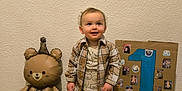 Elijah participe au concours pour gagner de l'argent avec cette photo : baby, balloon, bear, birthday, cardboard, celebration, child, clothing, cute, floor, indoors, number_one, party, photo_collage, plaid_shirt, smiling, socks, standing, toddler, wall