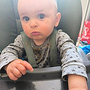 Elijah participe au concours pour gagner de l'argent avec cette photo : baby, child, high_chair, food_stains, star_pattern, clothing, face, eyes, hand, messy, indoor, person, seat, straps, expression, infant, table, curious, skin, portrait