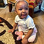 baby, child, smiling, headband, bow, socks, pants, shirt, floor, rug, wooden_floor, indoor, furniture, colorful_chair, happy, cute, person, portrait, seated, earrings