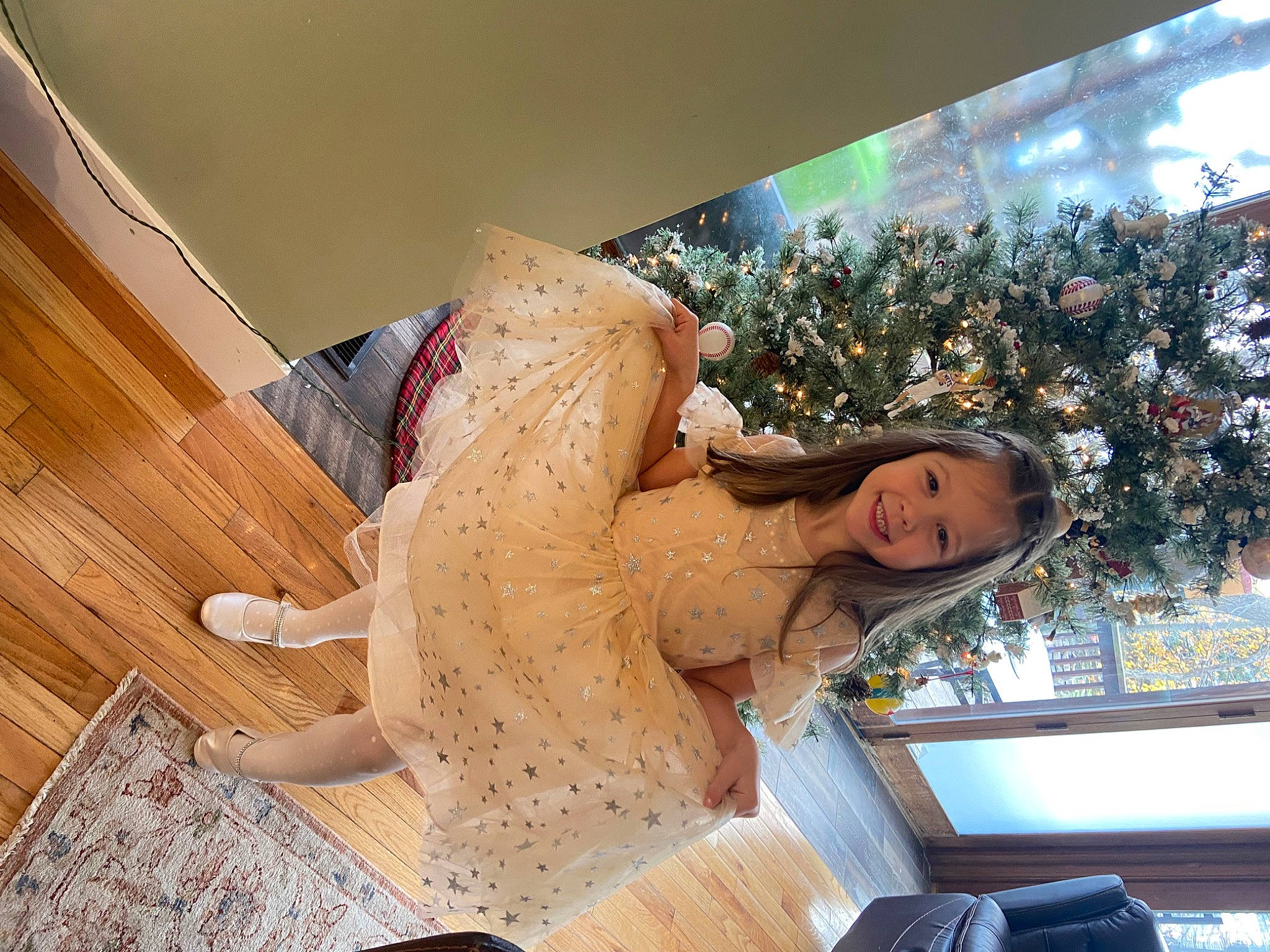 Tessa is registered to the contest to win money with this photo: abdomen, art, christmas_tree, dress, event, eyewear, fashion_accessory, fashion_design, flooring, fun, hardwood, human_leg, joy, leisure, person, retail, room, smile, thigh, trunk