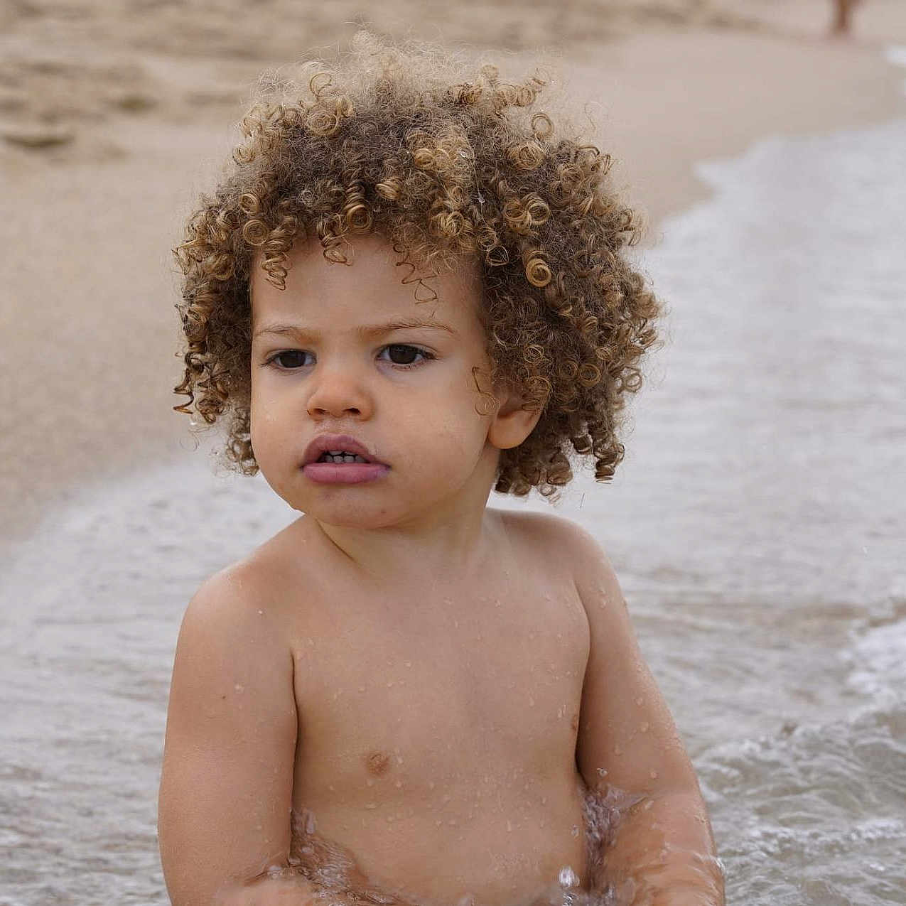 Jaron participe au concours pour gagner de l'argent avec cette photo : bare_chest, beach, child, curly_hair, daytime, expression, nature, ocean, outdoor, play, portrait, sand, sitting, skin, summer, toddler, vacation, water, waves, young_child