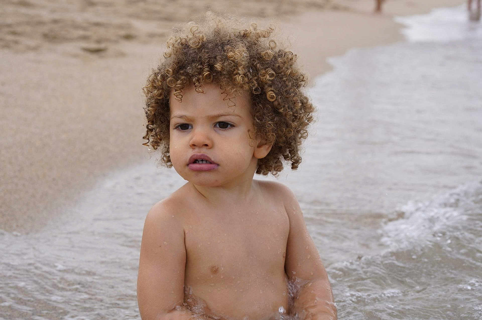 Jaron participe au concours pour gagner de l'argent avec cette photo : bare_chest, beach, child, curly_hair, daytime, expression, nature, ocean, outdoor, play, portrait, sand, sitting, skin, summer, toddler, vacation, water, waves, young_child