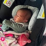 baby, infant, car_seat, blanket, pacifier, clothing, face, head, person, child, newborn, seatbelt, safety, indoors, cozy, cute, sleepwear, pink, soft, resting