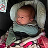 Kiara is registered to the contest to win money with this photo: newborn, baby, car_seat, blanket, mitten, face, headrest, infant, child, clothing, pink, black, white, seatbelt, person, portrait, indoors, cute, soft, warm