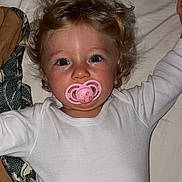 Lïyah a rejoint le concours — aidez-le/la à gagner de superbes lots ! bed, bedding, blanket, child, cute, emojis, face, flash, hair, indoor, infant, lying_down, pacifier, pillow, portrait, red_eye, sheet, smile, toddler, white_onesie