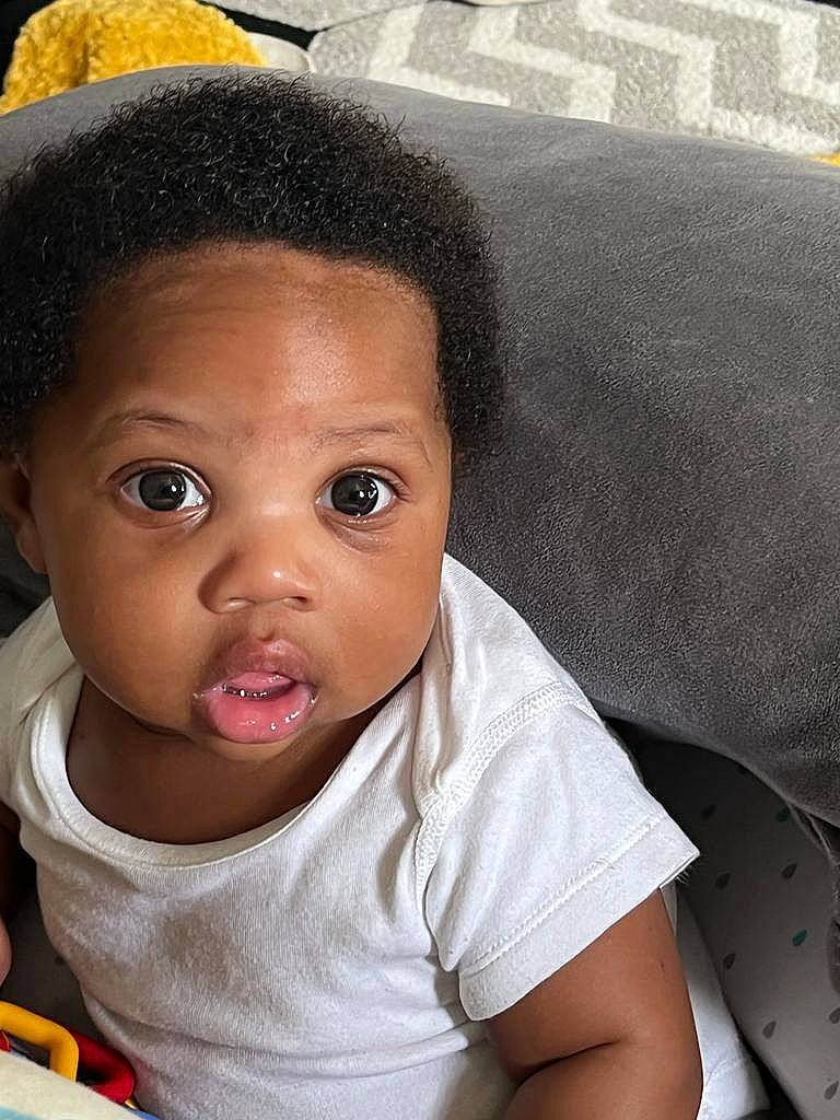 Tristan is registered to the contest to win money with this photo: baby, black_hair, cap, cheek, chin, comfort, cool, ear, eye, eyebrow, eyelash, forehead, happy, iris, lip, mouth, nose, person, skin, sleeve