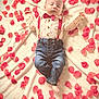 baby, infant, sleeping, bow_tie, suspenders, jeans, rose_petals, blanket, portrait, soft_lighting, top_view, adorable, tiny_feet, clothing, heart_pattern, props, cozy, celebration, peaceful, newborn