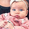 baby, blue_eyes, headband, pink_outfit, polka_dots, infant, cute, portrait, hands, bracelet, person, child, indoor, cozy, soft_fabric, closeup, face, expression, young, adorable