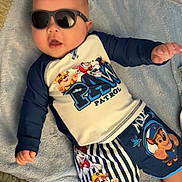 Kyaire joined the competition — help win amazing prizes! baby, child, sunglasses, blue_blanket, paw_patrol, clothing, shorts, shirt, lying_down, indoors, cute, infant, smiling, head, face, person, baby_clothes, relaxing, toy_theme, playful