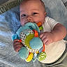 baby, infant, toy, blanket, soft_toy, colorful, ribbons, cute, child, lying_down, hand, face, blue, white_clothing, play, early_childhood, indoor, closeup, person, smiling