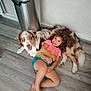 Viego a rejoint le concours — aidez-le/la à gagner de superbes lots ! child, dog, curly_hair, indoor, floor, wooden_floor, smiling, happy, pet, laying_down, brown_and_white_dog, casual_clothing, radiator, metal_bin, home, relaxed, cute, companion, friendship, portrait