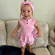 Cora joined the competition — help win amazing prizes! baby, blanket, child, clothing, couch, cute, furniture, girl, happy, headband, home, indoor, person, pink_outfit, playful, portrait, smile, standing, toddler, young_child