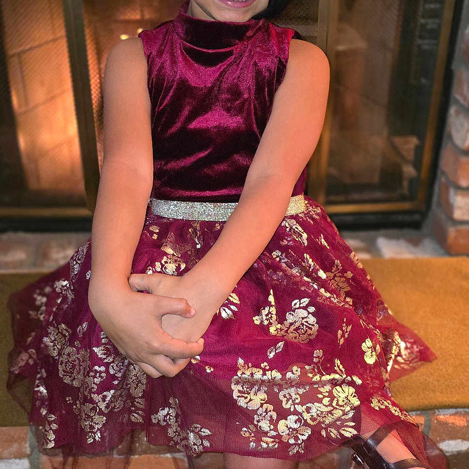 Grae is registered to the contest to win money with this photo: child, clothing, costume, dress, eveningdress, face, female, fireplace, footwear, formalwear, girl, head, highheel, indoors, person, photography, portrait, sandal, shoe, skirt