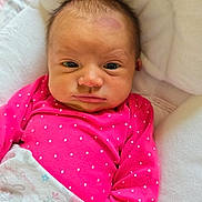 Everly Rose is registered to the contest to win money with this photo: baby, infant, child, pink_clothing, polka_dots, blanket, cushion, face, head, hand, indoor, portrait, newborn, sleepy, wrapped, cute, soft, resting, person, young