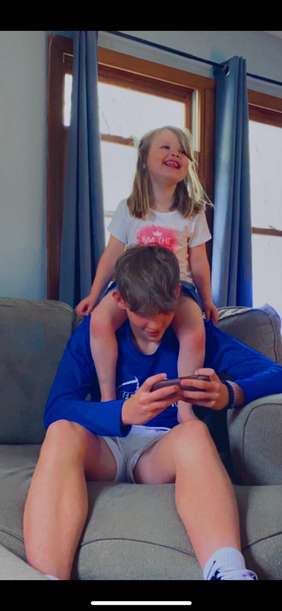 Averey is registered to the contest to win money with this photo: blue, comfort, curtain, electric_blue, event, facial_expression, fun, happy, human_leg, joint, joy, knee, lap, leg, leisure, muscle, person, shorts, shoulder, sitting