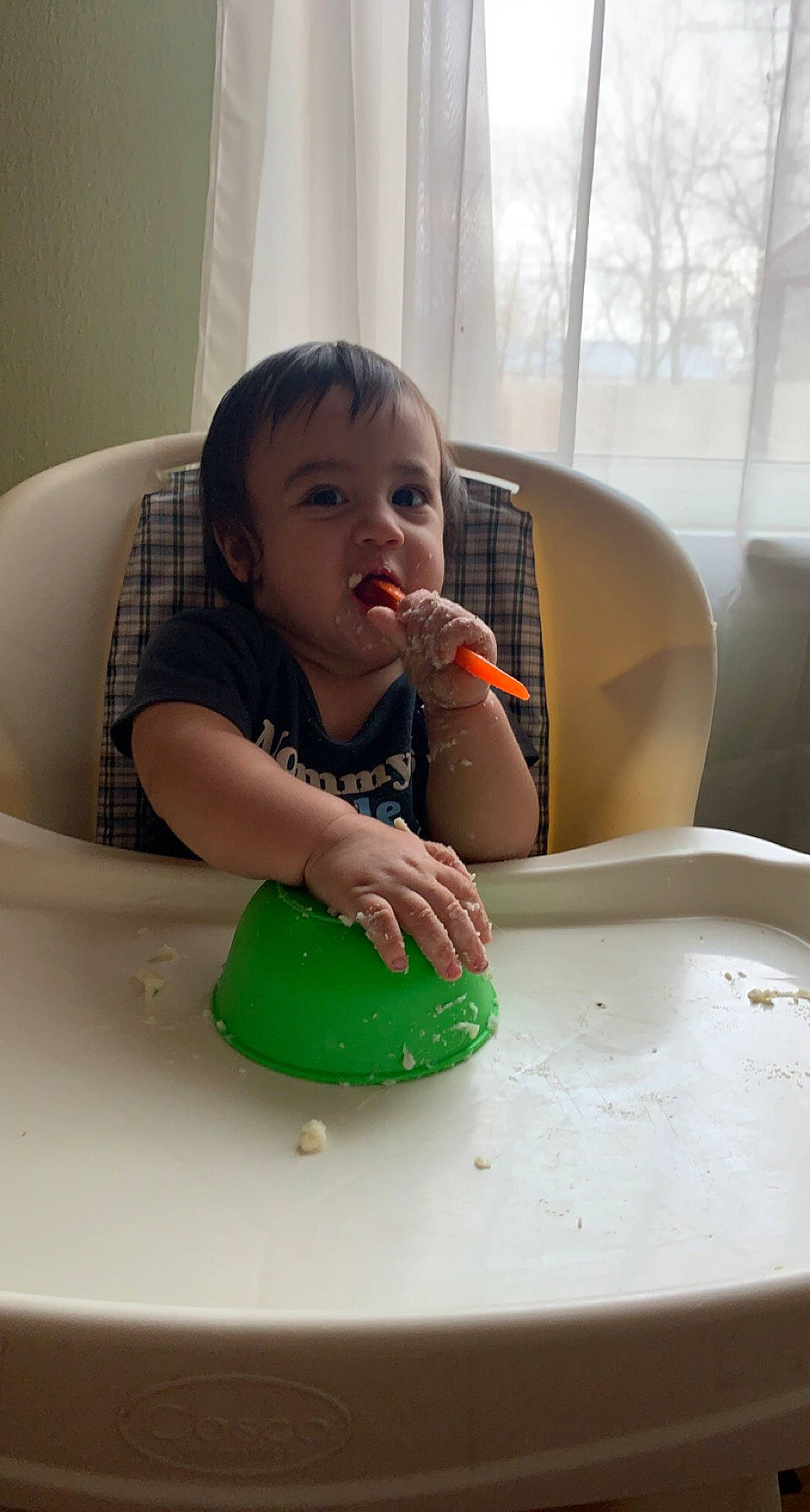 Titus is registered to the contest to win money with this photo: arm, baby, baby_playing_with_toys, cheek, child, dishware, finger, flooring, fun, head, person, plate, room, serveware, sitting, skin, table, tableware, toddler, window