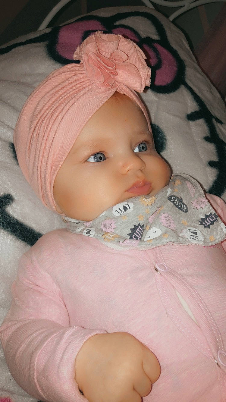 Jeanne participe au concours pour gagner de l'argent avec cette photo : baby, baby_products, baby_toddler_clothing, bonnet, cheek, child, comfort, eye, eyelash, fashion_accessory, human_body, iris, linens, lip, mouth, nose, peach, person, pink, skin