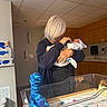 Killian joined the competition — help win amazing prizes! baby, bassinet, blanket, dinosaur_toy, hat, holding, hospital, hospital_room, indoor, infant, knitted_toy, medical_gloves_box, newborn, nursery, person, silver_hair, sink, tender_moment, wooden_cabinet, wrapped_baby