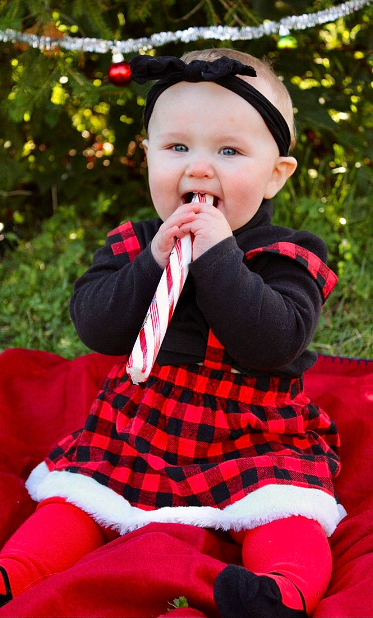 Leona is registered to the contest to win money with this photo: baby, baby_toddler_clothing, eye, face, flash_photography, grass, happy, headwear, lip, outerwear, people_in_nature, person, plaid, plant, red, sleeve, standing, tartan, textile, tie