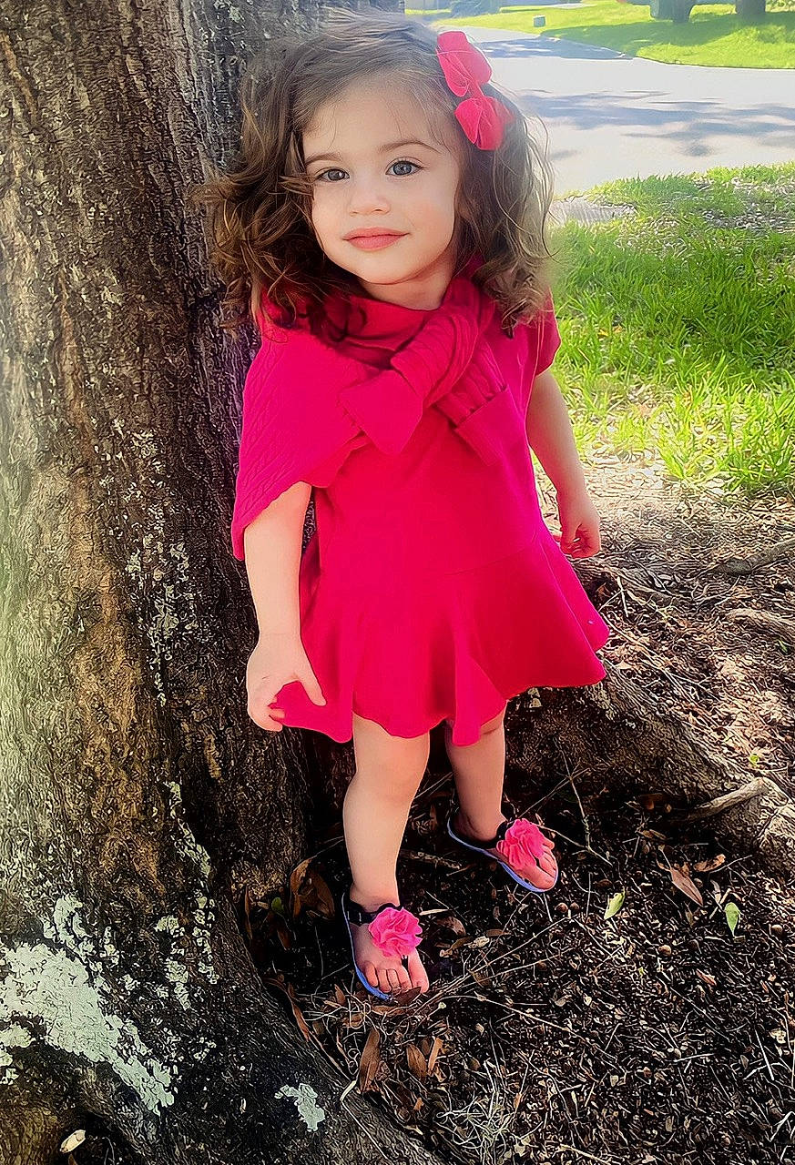Hailey is registered to the contest to win money with this photo: baby_toddler_clothing, brown_hair, child, clothing, eye, face, fun, grass, hair, happy, iris, joy, lip, magenta, people_in_nature, person, pink, plant, skin, toddler