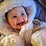 baby, child, smiling, hood, fur, coat, blue_eyes, teeth, happy, cute, winter_clothing, infant, portrait, warm, soft_texture, closeup, face, bundle, seatbelt, candid