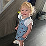 toddler, child, indoor, smiling, blonde_hair, denim_dress, sandals, socks, staircase, carpet, floor, wood_floor, happy, person, cute, young_child, home, casual_clothing, portrait, standing