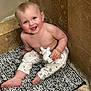 baby, infant, child, smile, bathroom, tile, bath_mat, plush_toy, sitting, bare_torso, onesie_pants, chubby_cheeks, blue_eyes, toes, happy, playful, portrait, floor, bathtub_edge, candor