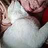 affection, cat, close_up, comfort, cuddle, elderly_person, face, fur, gentle, indoor, love, pet, portrait, relaxation, skin, smile, snuggling, warmth, whiskers, white_cat