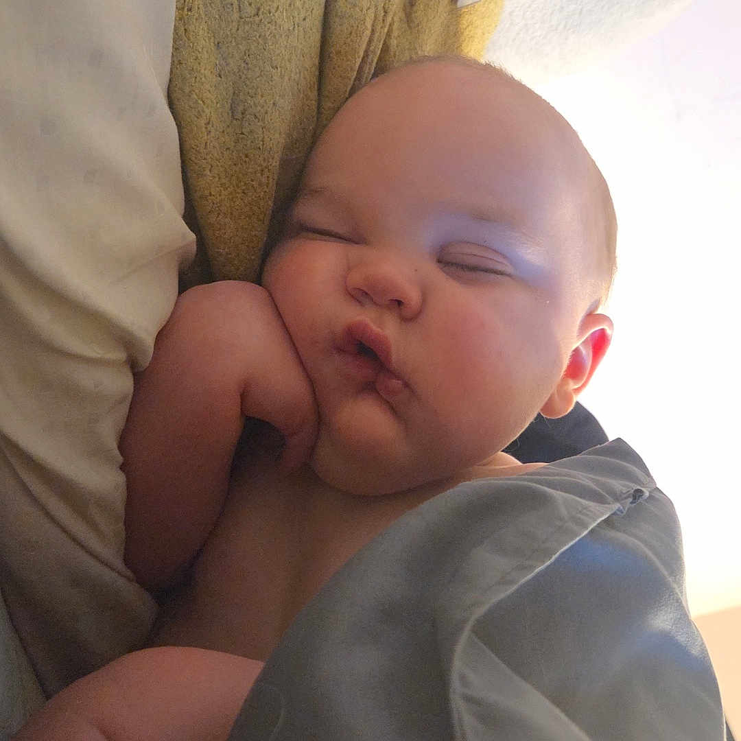 James is registered to the contest to win money with this photo: baby, sleeping, blanket, pillow, cheek, nap, peaceful, soft, skin, indoors, child, infant, cute, resting, wrapped, cozy, peace, toddler, face, hand