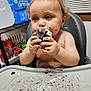 Leonidas is registered to the contest to win money with this photo: baby, child, chocolate, cream, curtains, cute, eating, face, food, hands, high_chair, indoor, kitchen, messy, plastic_tray, shelf, snack_time, snacks, toddler, window