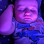 baby, sleeping, purple_light, infant, cute, face, tshirt, patterned_blanket, peaceful, closeup, child, resting, young, portrait, soft_light, indoors, cozy, relaxation, skin, hand