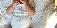 Taylor joined the competition — help win amazing prizes! baby, infant, child, onesie, headband, flower, blanket, texture, white, sock, skin, hands, face, eyes, cute, lying_down, soft_light, carpet, indoors, portrait