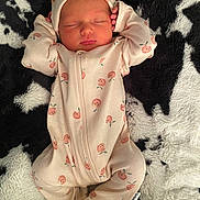 Taylor is registered to the contest to win money with this photo: baby, newborn, sleeping, onesie, hat, infant, cute, soft, blanket, plush, pattern, clothing, peaceful, rest, child, person, cozy, warm, face, hands