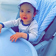 York participe au concours pour gagner de l'argent avec cette photo : baby, blue, cap, child, clothing, curly_hair, cute, expression, face, hand, high_chair, indoor, infant, person, seat, skin, soft_texture, table, toddler, young