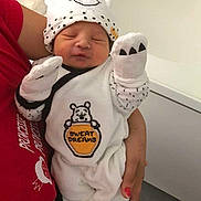 Skaylheur participe au concours pour gagner de l'argent avec cette photo : newborn, baby, infant, white_clothing, bear_hat, mittens, cute, sleeping, pout, adult_hand, red_shirt, indoor, person, holding, cozy, soft_toys, nursery, portrait, baby_outfit, sleepwear
