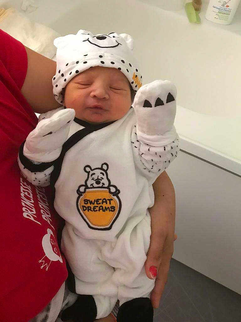 Skaylheur participe au concours pour gagner de l'argent avec cette photo : newborn, baby, infant, white_clothing, bear_hat, mittens, cute, sleeping, pout, adult_hand, red_shirt, indoor, person, holding, cozy, soft_toys, nursery, portrait, baby_outfit, sleepwear
