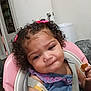 Layla is registered to the contest to win money with this photo: baby, blue_dress, child, curly_hair, cute, door, eating, expression, face, high_chair, home, indoor, kitchen, person, pink_bow, plastic_trash_can, seatbelt, snack, toddler, wall