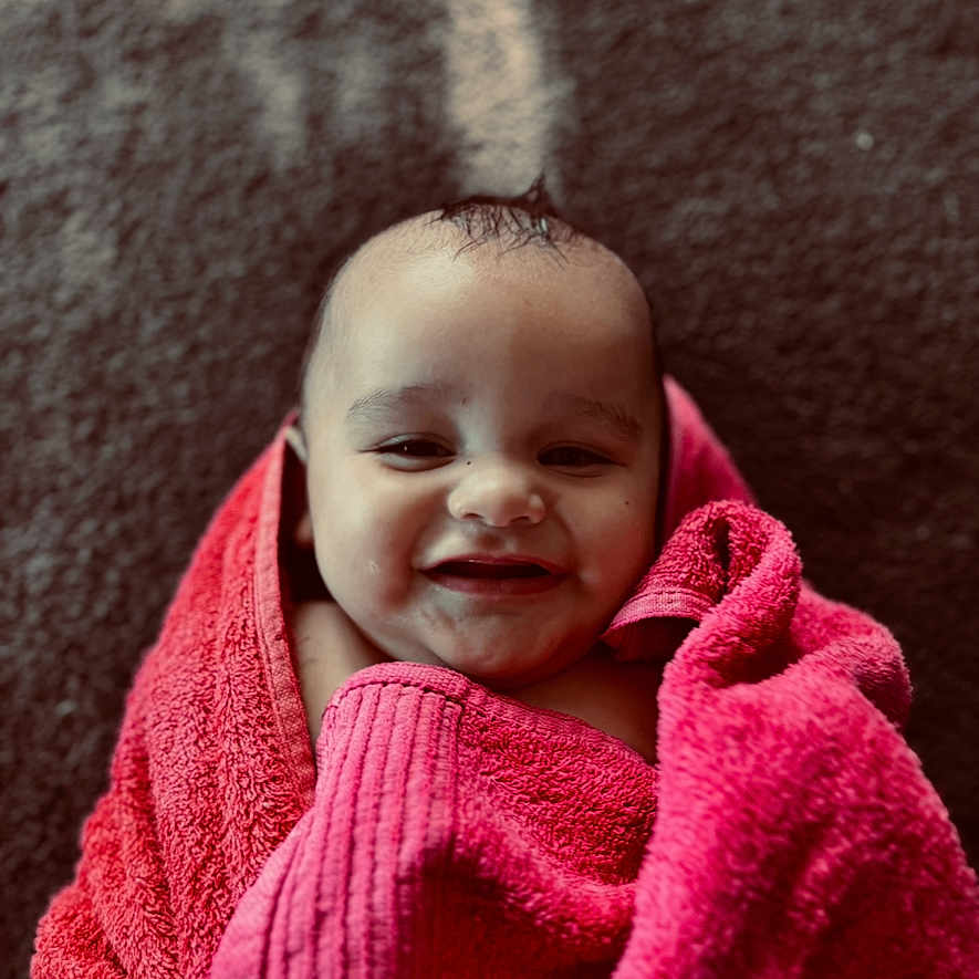 Kaitoa joined the competition — help win amazing prizes! baby, child, closeup, cute, expression, face, happy, head, indoor, infant, lying_down, person, pink, portrait, skin, smiling, soft, texture, towel, wrapped
