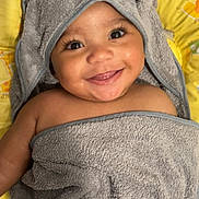 Liyad participe au concours pour gagner de l'argent avec cette photo : baby, infant, smile, towel, hood, elephant_towel, cute, closeup, portrait, wet_skin, cheeks, eyes, eyelashes, yellow_background, baby_bath, blanket, happy, playful, soft_texture, pillow