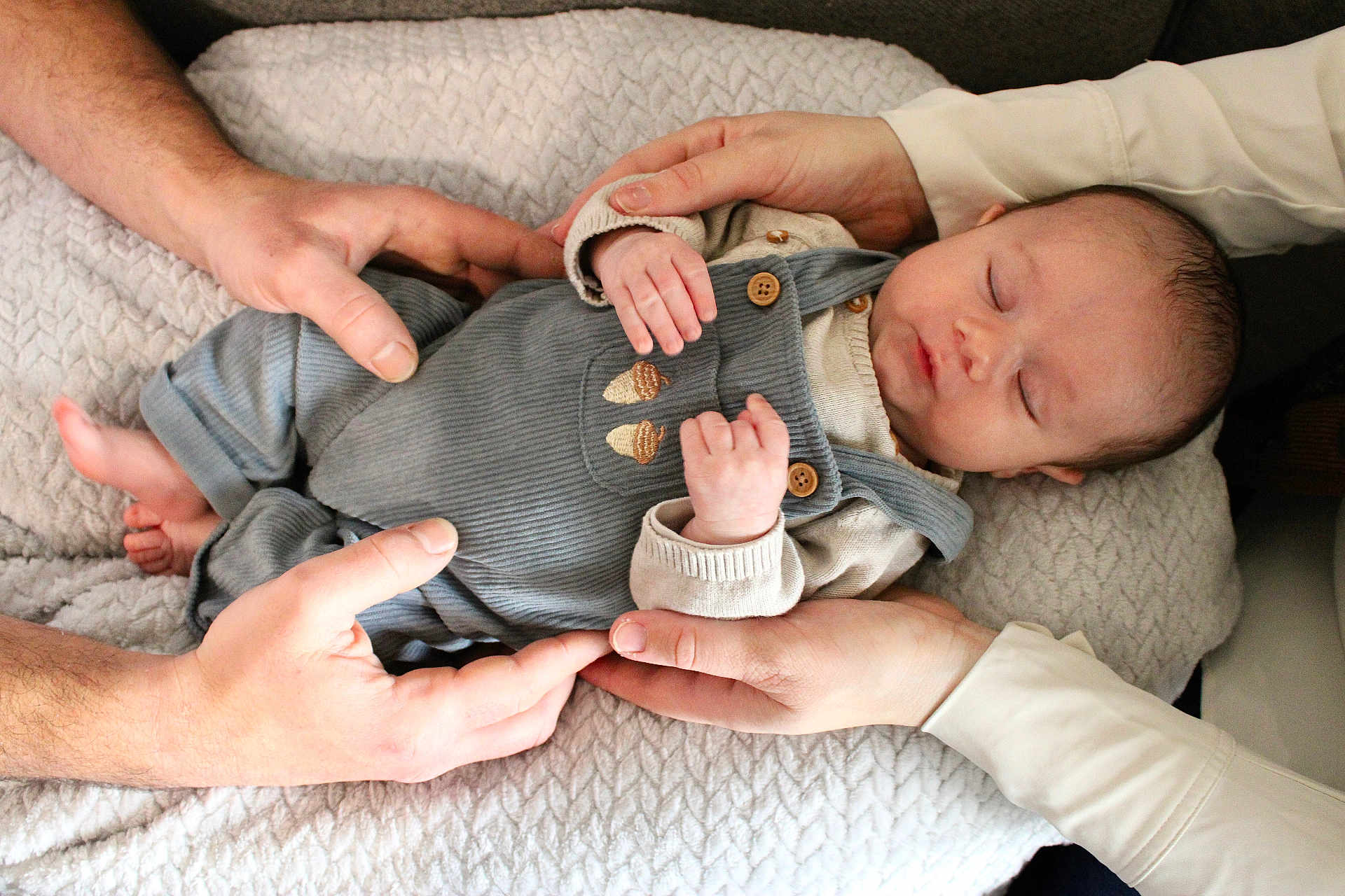 Ezekiel a rejoint le concours — aidez-le/la à gagner de superbes lots ! baby, newborn, infant, sleeping, hands, adult_hands, blanket, quilted_blanket, overalls, buttons, clothing, skin, face, eyes_closed, peaceful, holding, family, close_up, cozy, portrait