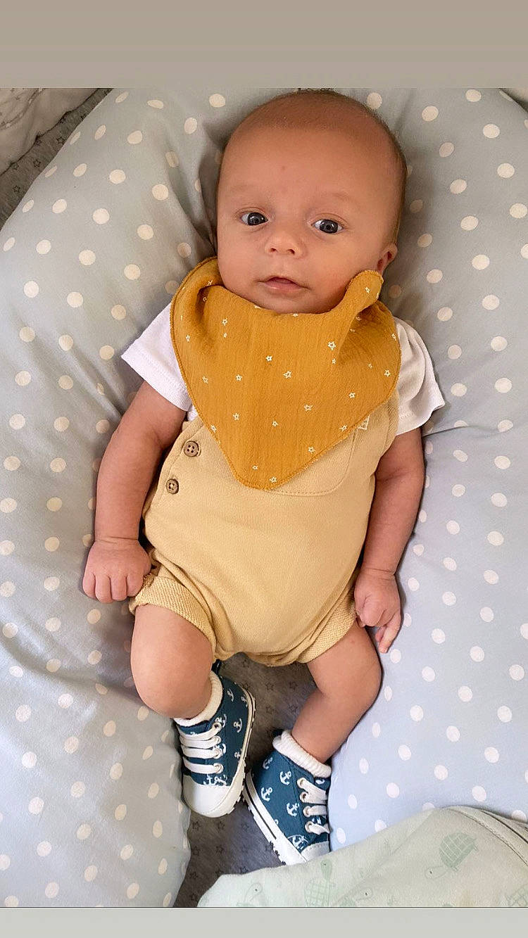 Maé participe au concours pour gagner de l'argent avec cette photo : baby, baby_products, baby_toddler_clothing, cheek, child, comfort, human_leg, leg, linens, pattern, person, pink, sitting, skin, sleeve, sock, textile, thigh, thumb, toddler