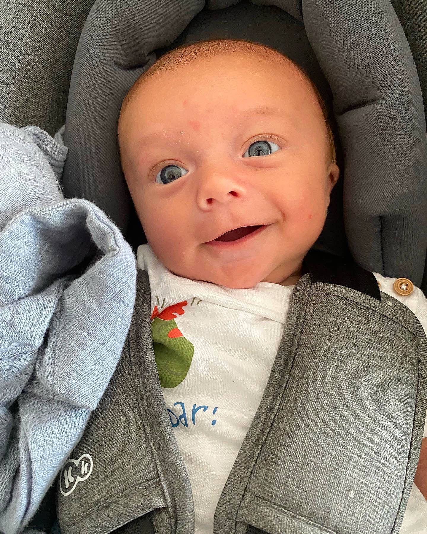 Maé a rejoint le concours — aidez-le/la à gagner de superbes lots ! baby, baby_carriage, baby_products, baby_toddler_clothing, beauty, cheek, collar, comfort, dress_shirt, formal_wear, grey, iris, outerwear, person, product, skin, sleeve, smile, textile, toddler