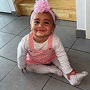 Harmonie a rejoint le concours — aidez-le/la à gagner de superbes lots ! toddler, child, pink_headband, bow, smile, white_shirt, pink_overalls, sitting, floor, tiles, wooden_stairs, indoor, cute, happy, playful, long_sleeves, headwear, person, young_child, casual_clothing