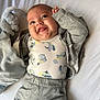 Isaho participe au concours pour gagner de l'argent avec cette photo : baby, infant, smiling, tongue_out, gray_clothing, nike, onesie, dinosaur_pattern, plush_toy, bunny, bed, blanket, cute, happy, lying_down, child, soft_toy, cozy, casual_wear, indoors